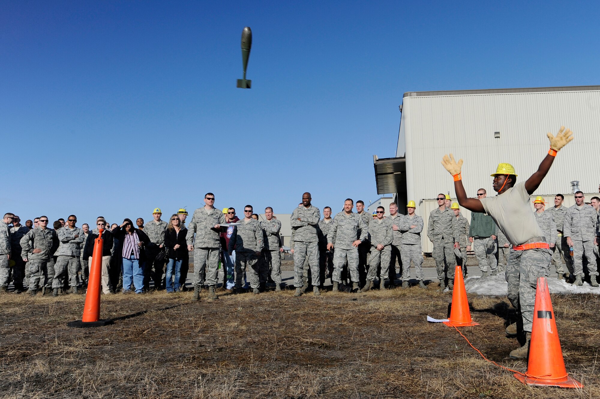 U.S. Air Force Airman 1st Class Harvey Lee, 354th Maintenance Squadron aircraft fuels systems journeyman, throws a bomb dummy unit during the 354th Maintenance Group Olympics BDU toss competition April 20, 2012, Eielson Air Force Base, Alaska. The event allowed Airmen to participate in several challenging maintenance activities which pushed Airmen to strive for excellence. (U.S. Air Force photo/Staff Sgt. Jim Araos)