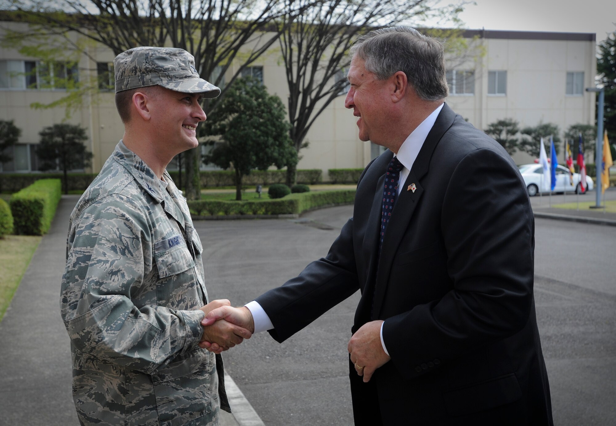 Col. Bill Knight (left), 374th Airlift Wing commander, greets Secretary of the Air Force Michael Donley in front of the 374th AW headquarters building at Yokota Air Base, Japan, April 24, 2012. Donley visited Yokota during a trip through the western Pacific region to meet with Airmen and thank them for their service. (U.S. Air Force photo/Staff Sgt Stacy Moless)