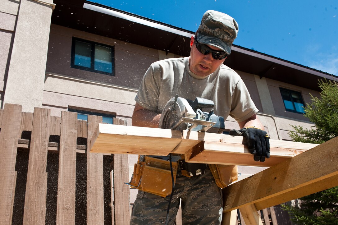 Tech. Sgt. Jeremiah Messimer, 28th Civil Engineer Squadron structures technician, cuts planks of wood into the proper lengths during the construction of a new deck at the Pine Tree Inn on Ellsworth Air Force Base, S.D., April 24, 2012. This new deck behind the Pine Tree Inn will provide a stable and safe area for guests staying at the inn. (U.S. Air Force photo by Airman 1st Class Alystria Maurer/Released)