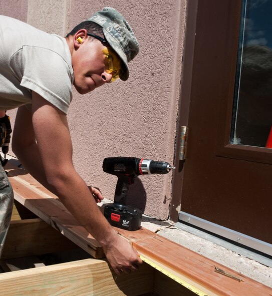 Airman 1st Class Zach Mitchell, 28th Civil Engineer Squadron structures technician, measures the length of a board while building a deck at the Pine Tree Inn on Ellsworth Air Force Base, S.D., April 24, 2012. Many updates and periodic maintenance are occuring on Ellsworth in preparation for upcoming 70th Anniversary Celebrations. (U.S. Air Force photo by Airman 1st Class Alystria Maurer/Released)