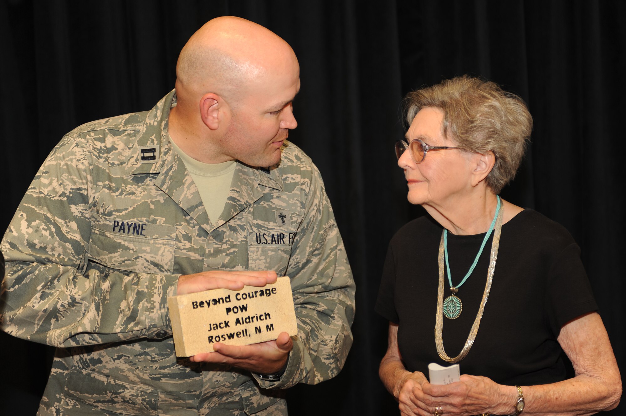 U.S. Air Force Capt. Joshua Payne presents Dorothy Cave with a memorial brick dedicated to her husband Jack Aldrich at the Landing Zone at Cannon Air Force Base, N.M., April 24,2012. Aldrich was a Bataan Death March POW during World War II. (U.S. Air Force photo by Airman 1st Class Eboni Reece)