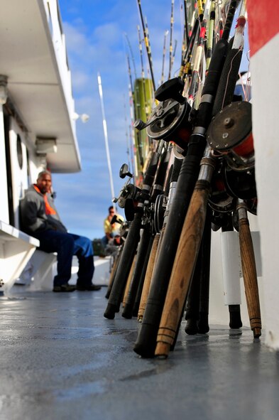 Fishing poles line the side of the ship as a fisherman sits and relaxes on the boat after arriving at the dock in Calabash, N.C. April 14, 2012. Shaw’s outdoor recreation offers several deep sea fishing trips throughout the spring and summer that Department of Defense ID card holders can take advantage of. (U.S. Air Force photo by Senior Airman Daniel Phelps/Released)