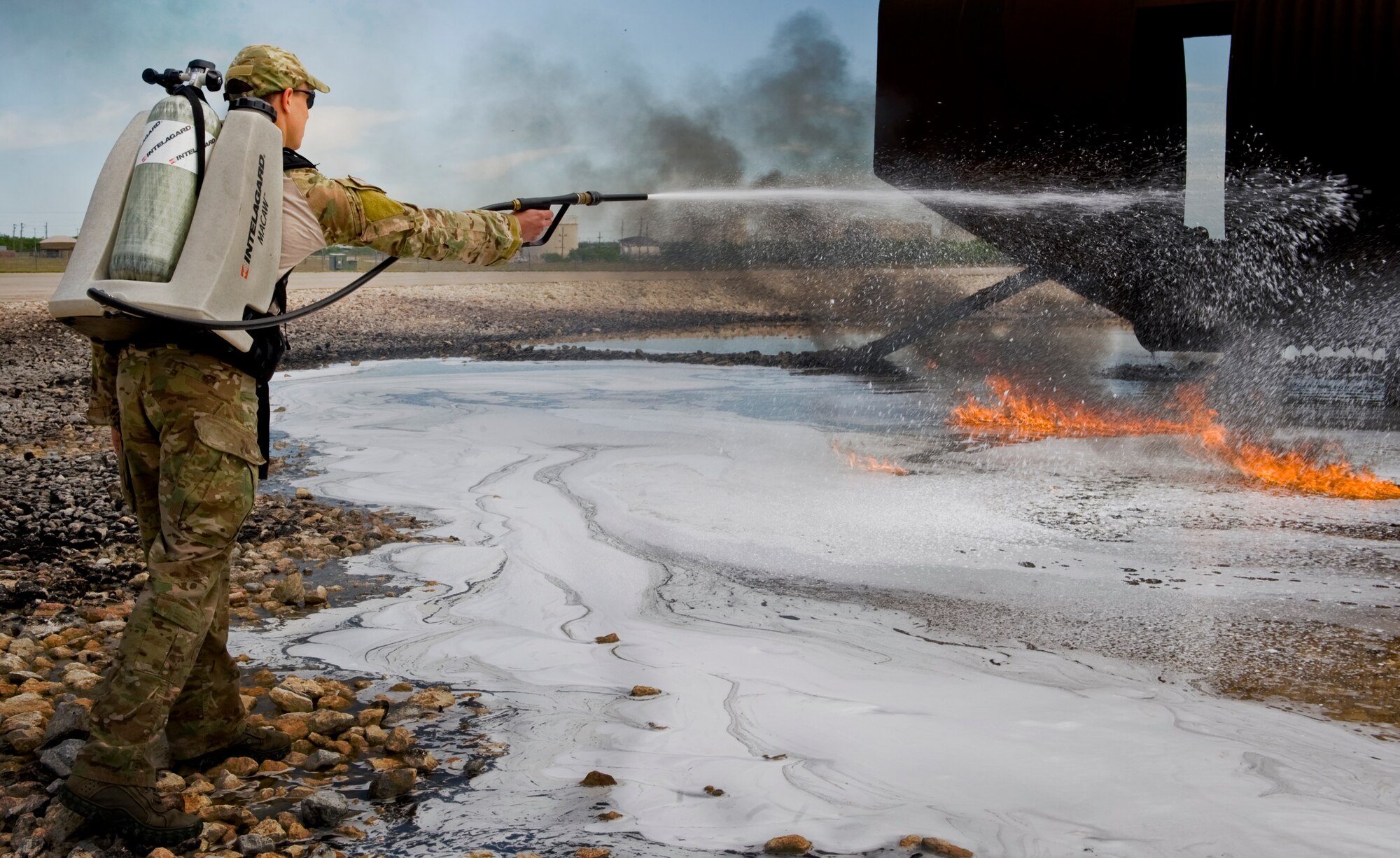 U.S. Air Force Capt. Michael Vins, 38th Rescue Squadron, Moody AFB, Ga. uses an Intelagard Macaw to extinguish a fire during training April 23, 2012, at Dyess Air Force Base, Texas. Dyess is one of five bases to use jet fuel for fire fighter training which provided pararescumen from Nellis AFB, Nev. and Moody the ideal emergency simulation. (U.S. Air Force photo by Airman 1st Class Jonathan Stefanko/ Released)