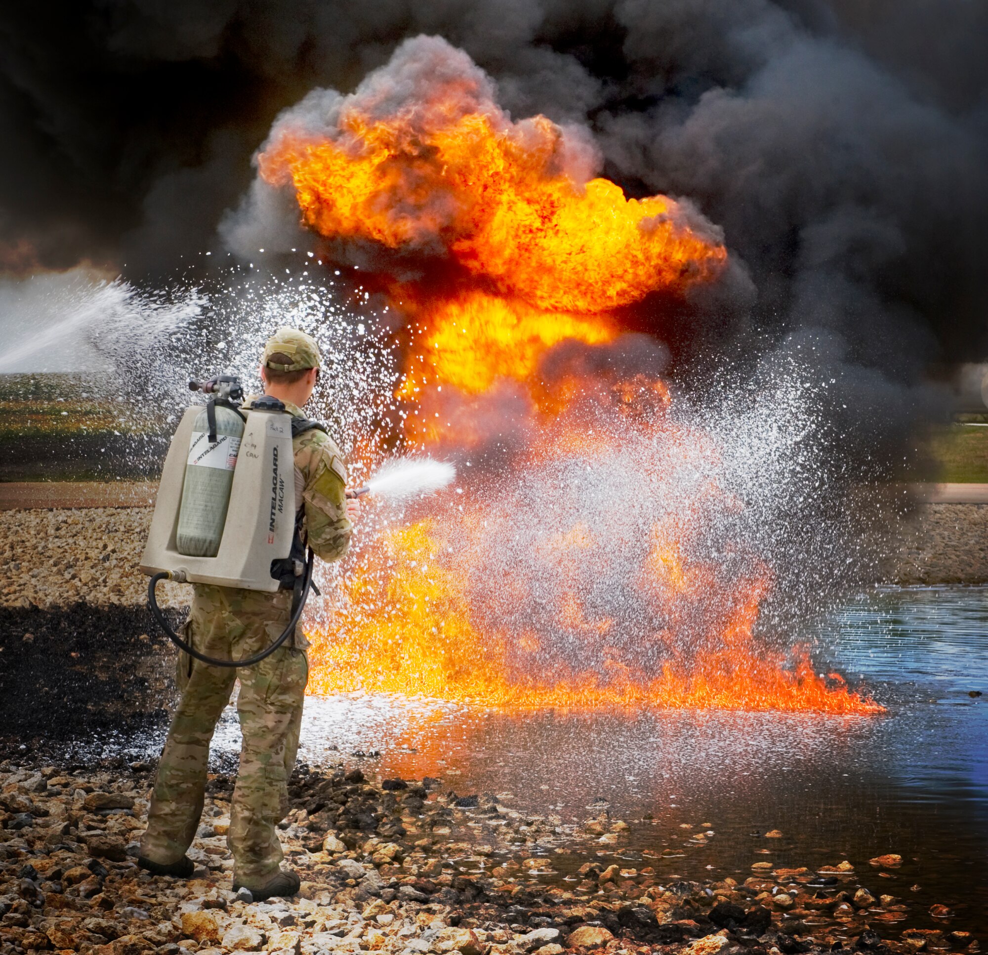 U.S. Air Force Capt. Michael Vins, 38th Rescue Squadron, Moody AFB, Ga.  uses an Intelagard Macaw to extinguish a fire during training April 23, 2012, at Dyess Air Force Base, Texas. Dyess is one of five bases to use jet fuel for fire fighter training which, provided pararescumen from Nellis AFB, Nev. and Moody the ideal emergency simulation. (U.S. Air Force photo by Airman 1st Class Jonathan Stefanko/ Released)