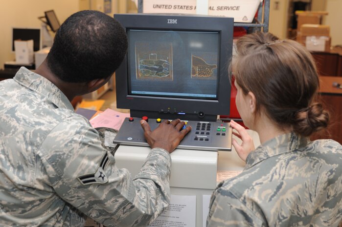 Airmen 1st Class Jessalyn Oglesby (right) and Jamal Snow security scan a package at Joint Base Charleston - Air Base April 10. The offical mail room center has to scan a certain percentage of the packages that arrive on base. Snow and Oglesby are 628th Communications Squadron knowledge operations management journeymen. (U.S. Air Force photo/ Airman 1st Class Chacarra Walker)