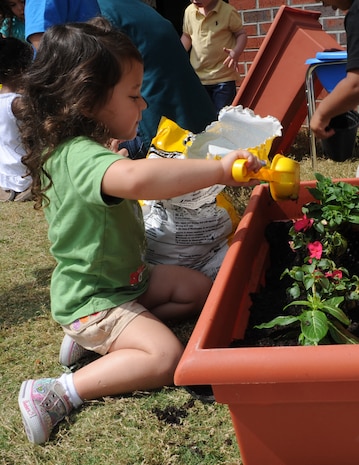 Makayla Parker plants a flower during the Joint Base Charleston - Air Base's event Child Development Center's Gardening with Parents April 20. Makayla’s father is Tech. Sgt. Marcus Parker, 437th Maintenance Operations Squadron. (U.S. Air Force photo/Airman 1st Class Chacarra Walker)