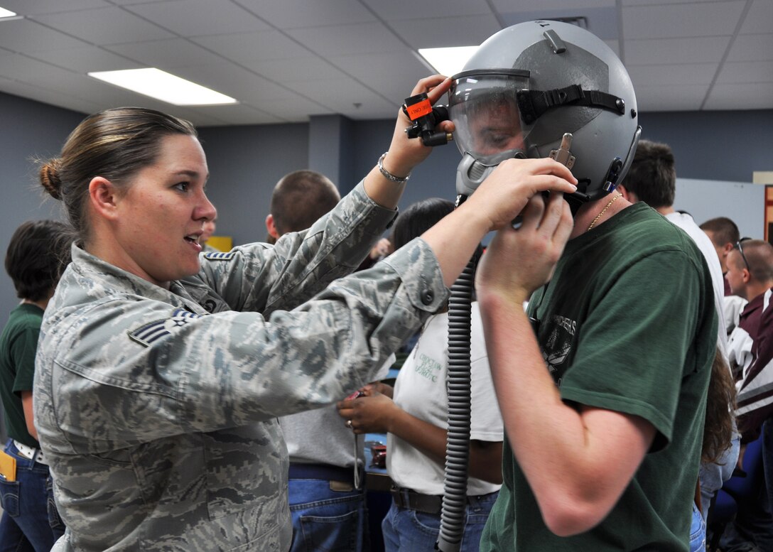 Staff Sgt. Tracey Stewart, 919th Operations Support Squadron, helps Ethan Small, a member of Choctawhatchee High School’s Air Force Junior ROTC, as he tries on an aircrew helmet and oxygen mask in the unit’s life support equipment section at Duke Field, Fla., April 24, 2012.  The wing invited senior cadets from five local area high schools to tour the base and receive a flight to help them explore Air Force careers through direct interaction with Duke Field’s Citizen Commandos. (U.S. Air Force photo/Tech. Sgt. Jasmin Taylor)