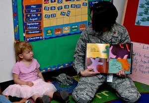 U.S. Air Force Maj. Elizabeth Najera, 633rd Medical Operations Squadron behavioral health flight commander, reads the book “My Many Colored Days,” by Dr. Suess as 3-year-old Alexis Taylor listens carefully during “Read to Kids Day,” at Langley Air Force Base, Va.,  Apr. 25, 2012. Read to Kids Day was sponsored by the Langley Family Advocacy office. (U.S. Air Force photo by Senior Airman Wesley Farnsworth)