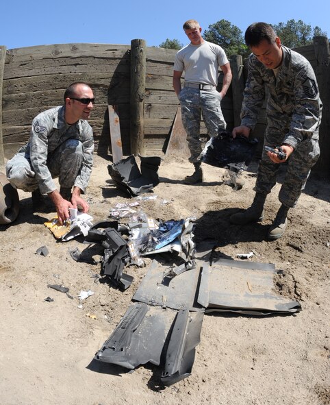 Airmen from the 372nd Training Squadron, Detachment 1, rummage through the remains of a detonated safe at the explosive ordnance disposal range on Seymour Johnson Air Force Base, N.C., April 24, 2012. The safe’s missing combination provided the 4th Civil Engineer Squadron EOD flight a training opportunity. (U.S. Air Force photo/Airman 1st Class Aubrey Robinson/Released)