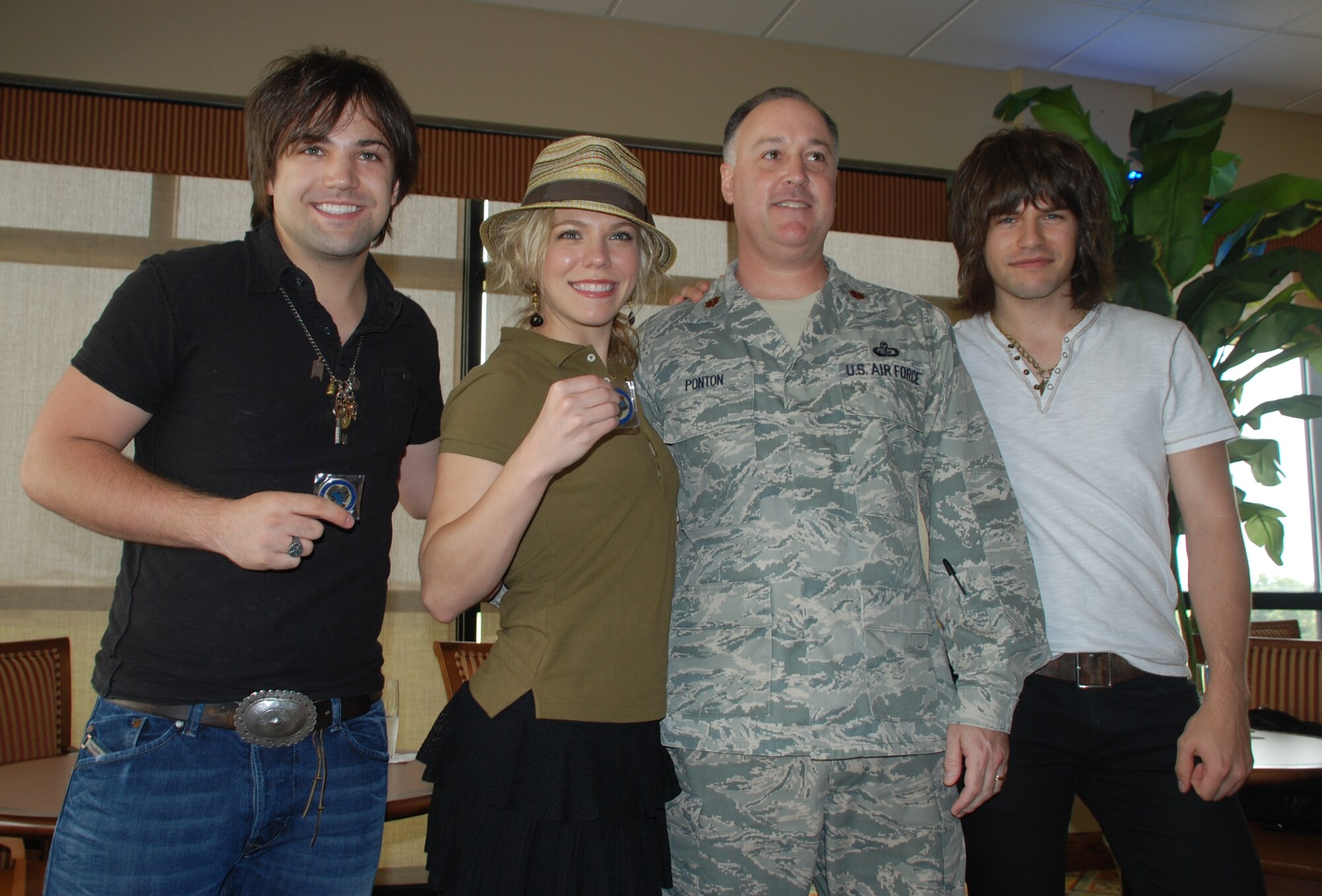 Maj. John Ponton, 81st Force Support Squadron commander, poses for a photo after presenting The Band Perry’s members, Neil, Kimberly and Reid, with a coin to thank them for coming out to the Bay Breeze Event Center at Keesler Air Force Base, Miss. for a meet-and-greet April 21, 2012. (U.S. Air Force photo by Staff. Sgt. Kimberly Rae Moore). 