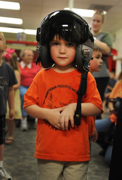 Ryan Spencer, student in First Presbyterian Preschool class, tries on a joint-helmeted, mounted-cueing system helmet during a tour of the flight line and the 77th Fighter Squadron at Shaw Air Force Base, S.C., March 30, 2012. The month of April is the Month of the Military Child. During this month, numerous events are held for children to recognize the sacrifices of children in military families. (U.S. Air Force photo by Senior Airman Tabatha McCarthy/released)