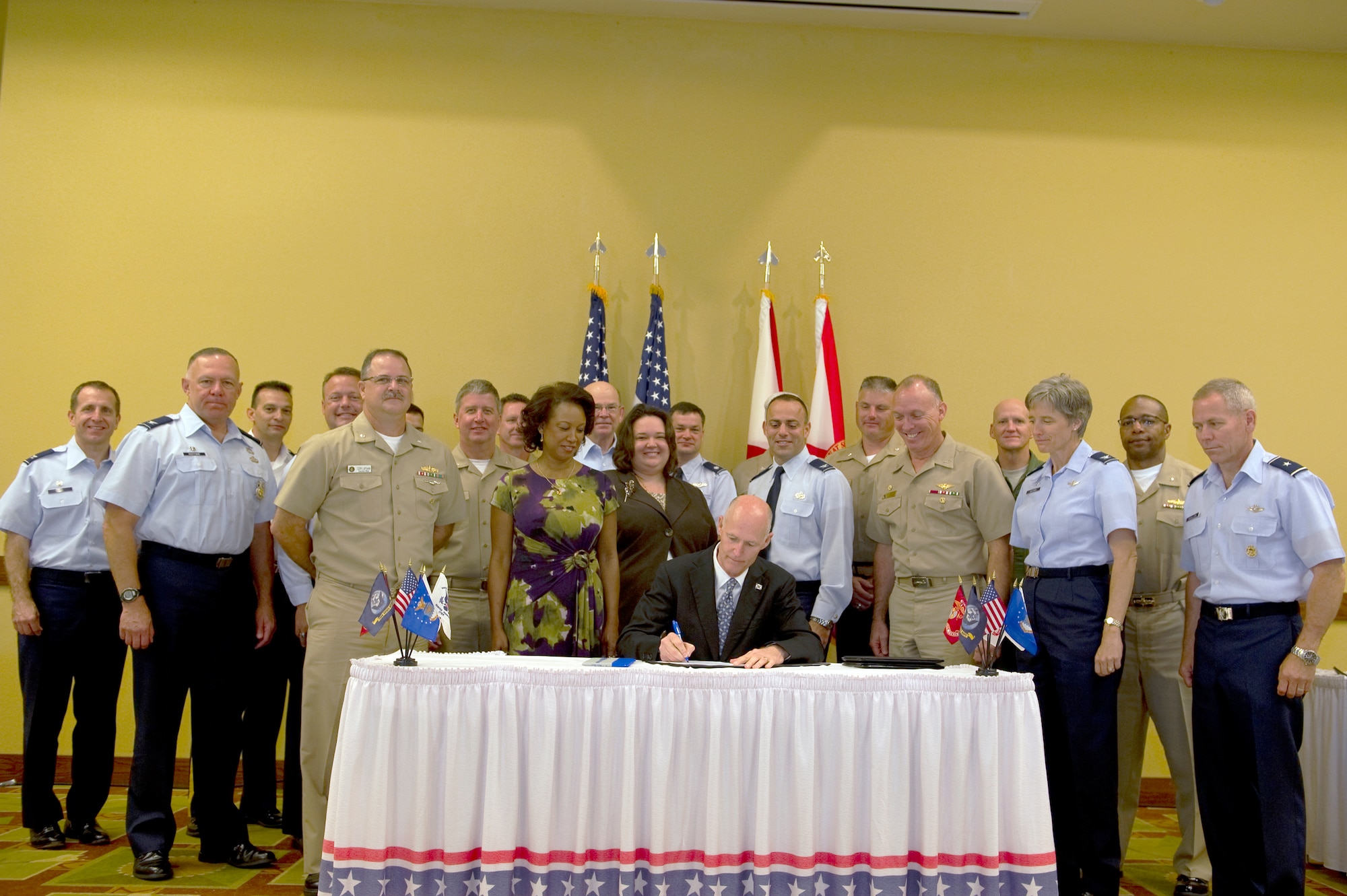 Rick Scott, governor of Florida, signs Florida House Bill 7075 at the Soundside Club on Hurlburt Field, Fla., April 11, 2012.  Base commanders from military installations throughout Florida came together to discuss projects to improve service integration and quality of life with the governor.  The bill will provide tools to safeguard military installations in the state.   (U.S. Air Force photo/Senior Airman Eboni Reams) 
