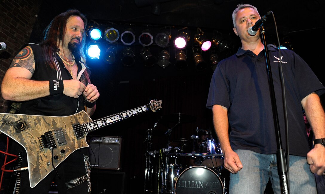 Maj. Henry Cecil (right) talks to the audience about the background of why the Air Force guitar was built as Lillian Axe lead guitarist Steve Blaze looks on April 21, 2012, at the Riverside Warehouse in Shreveport, La. Cecil and Blaze collaborated with guitar maker John Guilford to build the guitar to honor nine Airmen who were killed April 27, 2010, at the Kabul International Airport in Afghanistan. After Lillian Axe tours with the guitar, it will be raffled off with the proceeds going toward the Air Advisor Memorial. Cecil is an Air Force representative to the Federal Aviation Administration in Fort Worth, Texas. (U.S. Air Force photo/Tech. Sgt. Chris Powell)