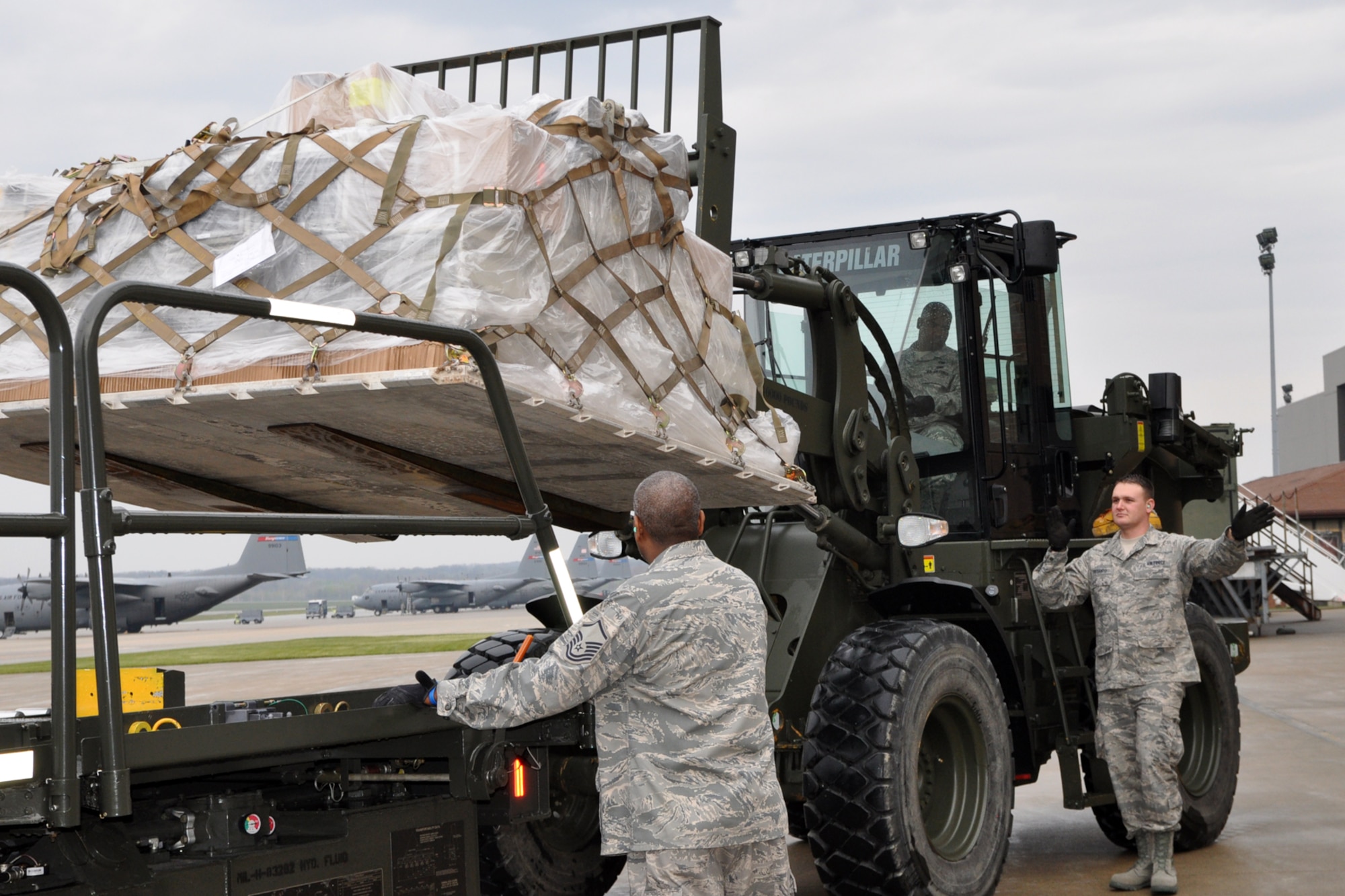 YOUNGSTOWN AIR RESERVE STATION, Ohio – Air Force Reserve Master Sgt. Calvin Barker watches as Tech. Sgt. Anthony Cresanto directs the operation of a forklift operated by Tech. Sgt. Chris Worthy on the flightline outside the Aerial Port Squadron (APS) hangar here, April 15, 2012. The Citizen Airmen, Aerial Porters assigned to the 76th APS, are loading the supplies on a ground cargo handling vehicle, known as a 60-K loader, for transfer to a C-17 cargo aircraft for a mission, organized by Cleveland-based MedWish International, to deliver the much needed materials to El Salvador. U.S. Air Force photo by Master Sgt. Bob Barko Jr. U.S. Air Force photo by Master Sgt. Bob Barko Jr.