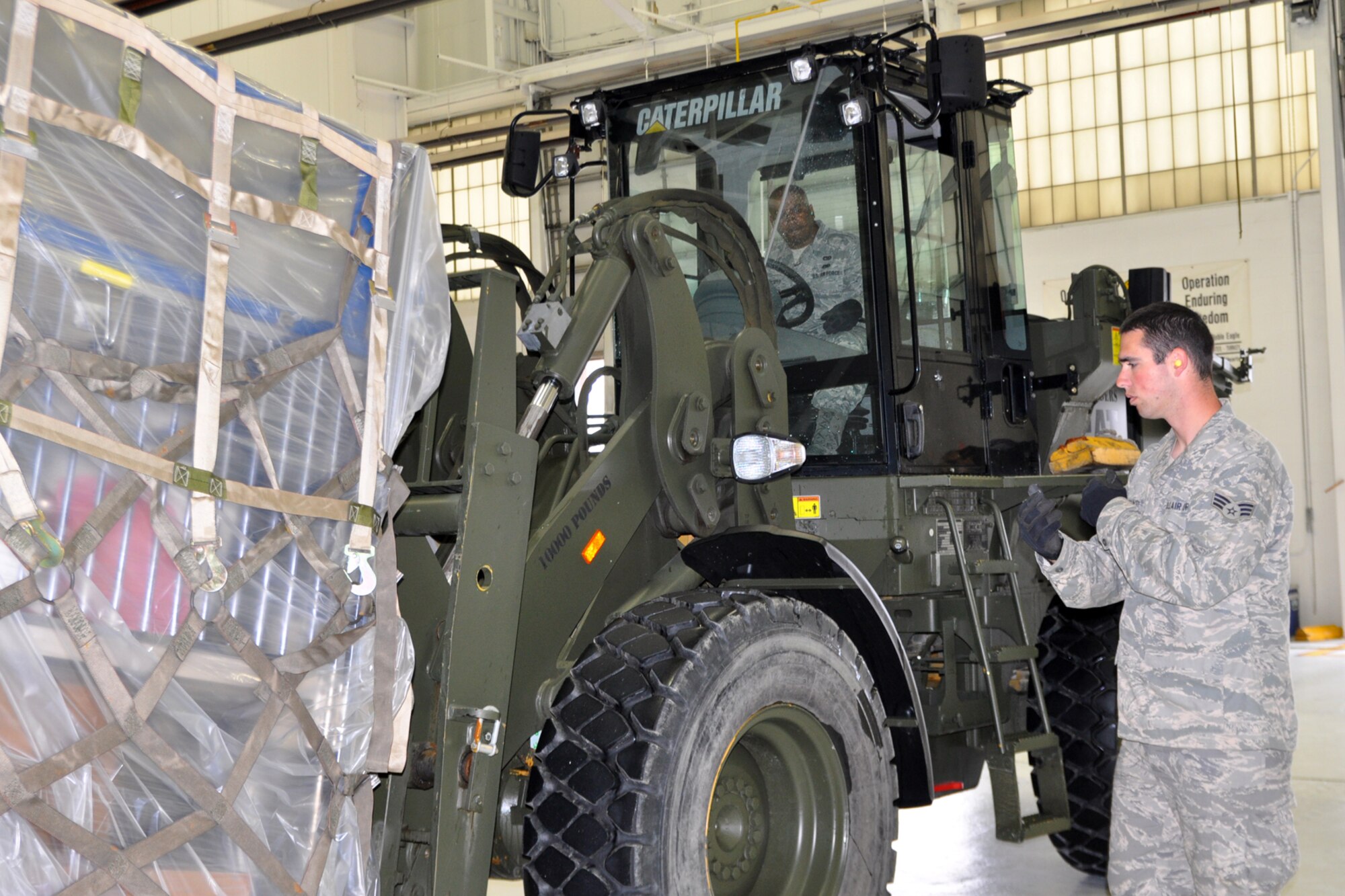 YOUNGSTOWN AIR RESERVE STATION, Ohio – Air Force Reserve Sr. Airman Steve Cresanto directs Tech. Sgt. Chris Worthy as he picks up a load of humanitarian supplies with a forklift at the 76th Aerial Port hangar here, April 15, 2012. Both Citizen Airmen are Aerial Porters assigned to the 76th APS and are working to load the supplies aboard a C-17 cargo aircraft for a mission, organized by Cleveland-based MedWish International, to deliver the much needed materials to El Salvador. U.S. Air Force photo by Master Sgt. Bob Barko Jr. 