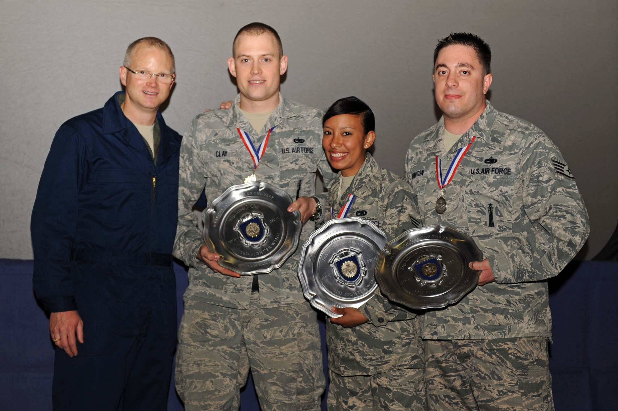 SPANGDAHLEM AIR BASE, Germany – From left, Col. Chris Weggeman, 52nd Fighter Wing commander, and 52nd Aircraft Maintenance Squadron load crew members Staff Sgt. James Clay, Senior Airman Michele Atencio, and Staff Sgt. Michael Elkington, pose for a photo during the 2011 Maintenance Professional of the Year banquet at Hangar 1 here April 21. Clay, Atencio and Elkington were announced as the winners of the 2011 52nd FW Weapons Load Crew of the Year Award during the banquet. Weggeman, wearing coveralls to show support for the maintainers, joined Airmen from the 52nd Maintenance Group and 52nd Munitions Maintenance Group attending the banquet to recognize contribution made by maintenance professionals to mission readiness throughout the year. The banquet also included awards for Airmen and teams who went above and the beyond the established standards for their job performance. (U.S. Air Force photo by Airman 1st Class Matthew B. Fredericks/Released)