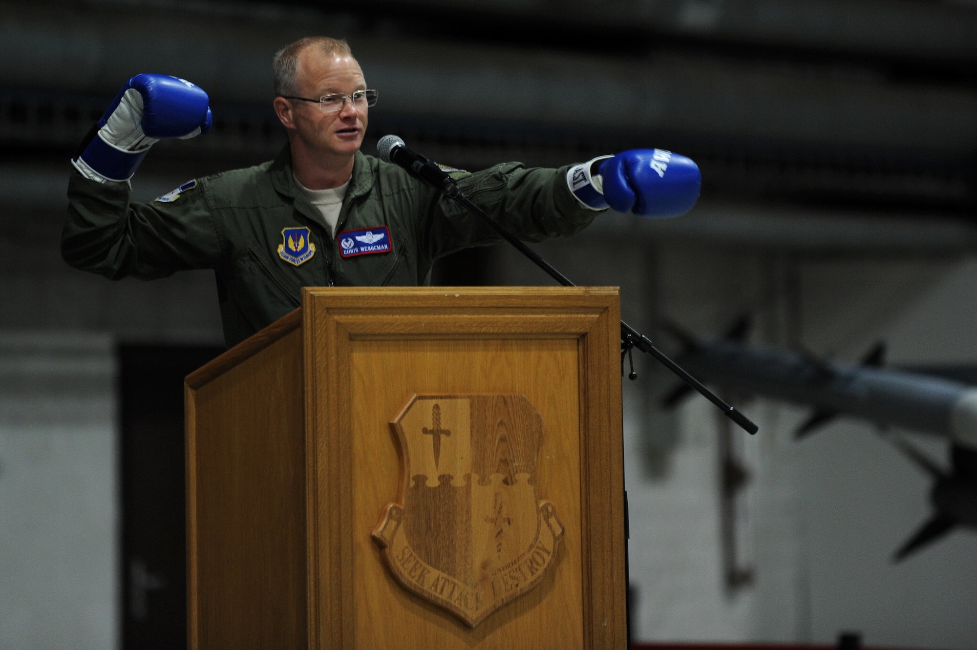 SPANGDAHLEM AIR BASE, Germany – Col. Chris Weggeman, 52nd Fighter Wing commander, uses boxing gloves to help illustrate the topic of his speech “Fly, Flight, Win” during the 2011 Maintenance Professional of the Year banquet at Hangar 1 here April 21. Airmen from the 52nd Maintenance Group and 52nd Munitions Maintenance Group attended the banquet to recognize contributions made by maintenance professionals to mission readiness throughout the year. The banquet also included awards for Airmen and teams who went above and the beyond the established standards for their job performance. (U.S. Air Force photo by Airman 1st Class Matthew B. Fredericks/Released)