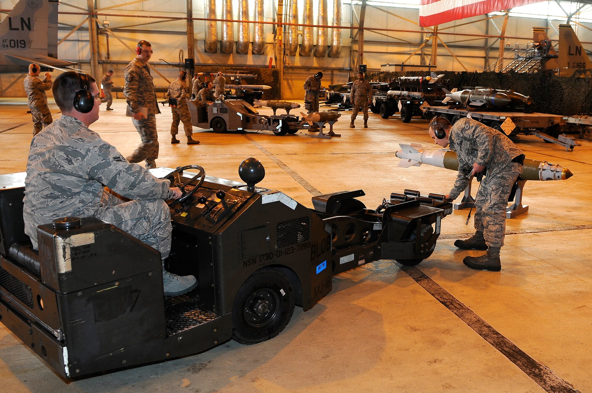 ROYAL AIR FORCE LAKENHEATH, England -- Airman 1st Class Evan Schroeder (left), and Staff Sgt. Christopher Witt (right), 492nd Aircraft Maintenance Unit weapons load crew members, prepare to load a Guided Bomb Unit-38 munition onto a bomb lift truck during the quarterly Load Crew Competition April 20, 2012. The competition features the best load crew teams from the 492nd, 493rd and 494th AMUs. The winner is determined by the fastest time loading munitions with the least amount of errors.  (U.S. Air Force photo by Staff Sgt. Connor Estes)