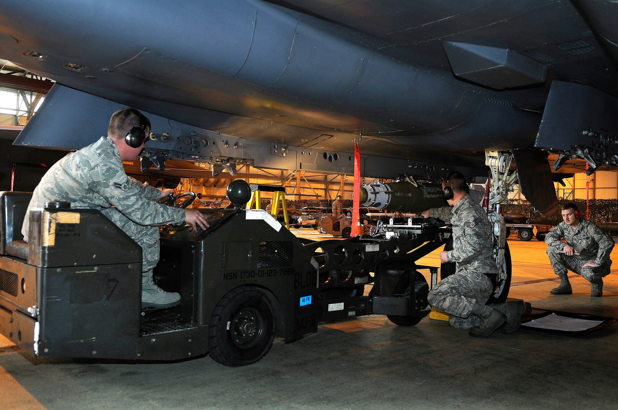 ROYAL AIR FORCE LAKENHEATH, England -- Master Sgt. Charles Evelo, 48th Munitions Operation Squadron Loading standardization crew member (right), evaluates how 492d Aircraft Maintenance Unit weapons load crew members Airman 1st Class Evan Schroeder (left) and Staff Sgt. Christopher Witt (middle) load a Guided Bomb Unit-38 munition onto an F-15E Strike Eagle during the quarterly Load Crew Competition April 20, 2012. The competition features the best load crew teams from the 492nd, 493rd and 494th AMUs. The winner is determined by the fastest time loading munitions with the least amount of errors.  (U.S. Air Force photo by Staff Sgt. Connor Estes)