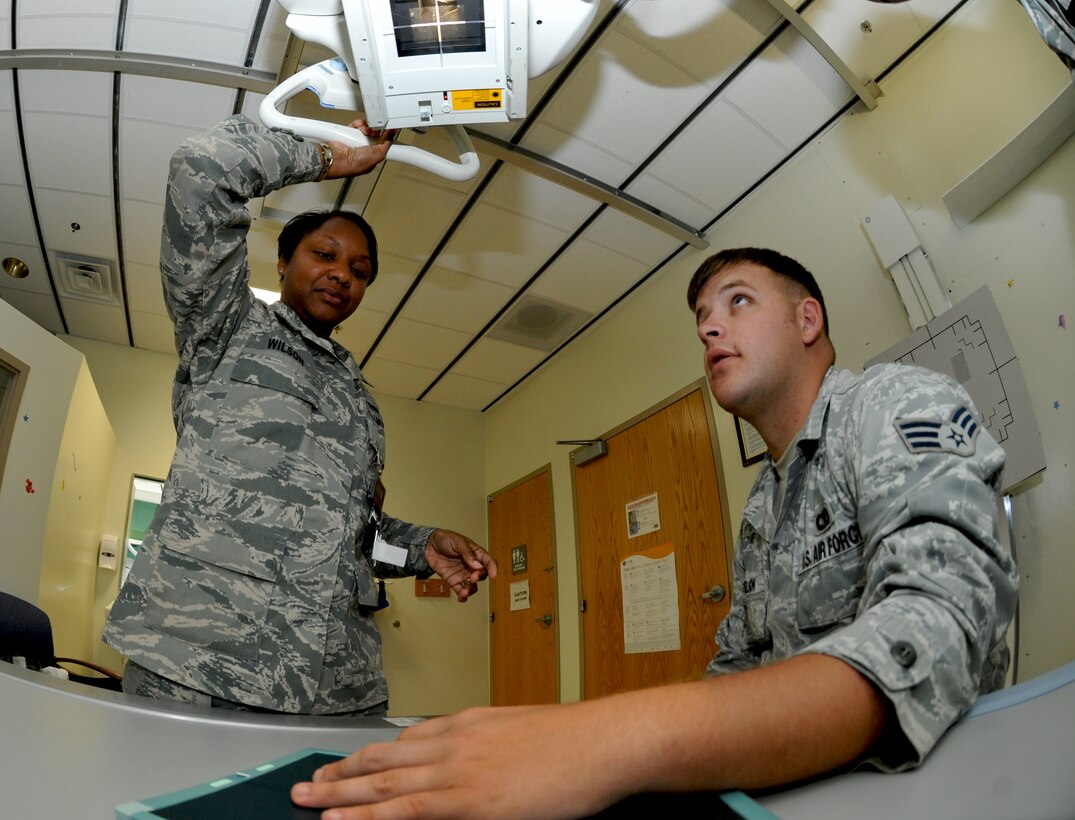 ANDERSEN AIR FORCE BASE, Guam— Master Sgt. Devin Wilson, 36th Medical Group, aims the diagnostic imaging machine as she explains the  procedure to Senior Airman Ben Nelson, 736th Security Forces Squadron, April 18. The imaging section of the clinic is a walk in appointment style, but the patient has to be referred by a healthcare provider. The clinic also supports outpatient process for military members and their dependants. (U.S. Air Force photo by Senior Airman Benjamin Wiseman/Released)