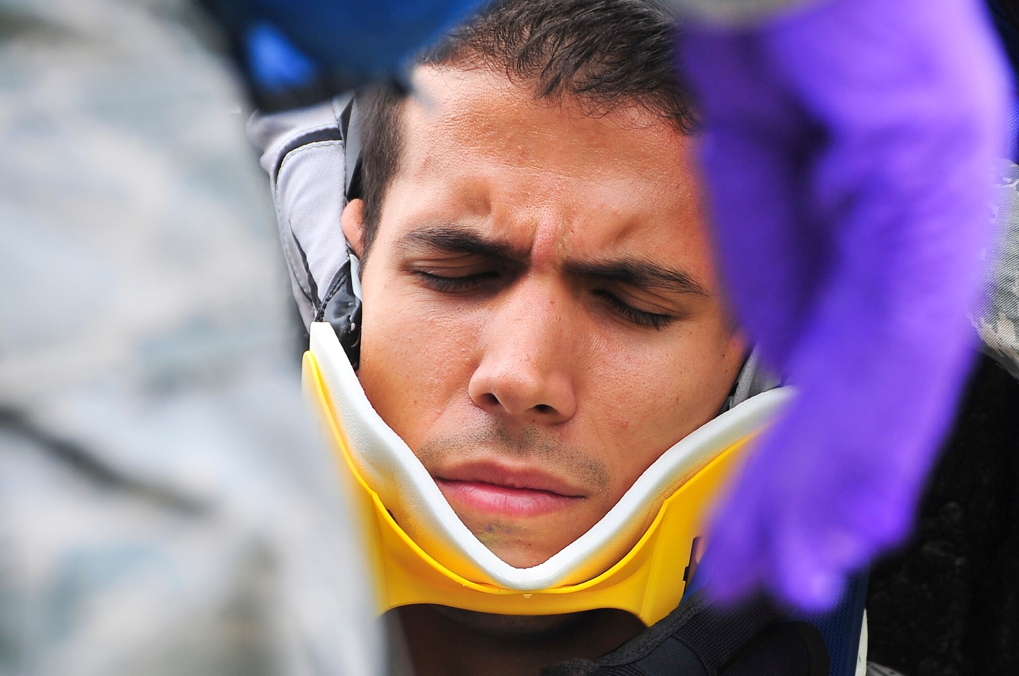 A patient braces himself as a neck brace is placed around his neck after a bus crash scenario during the Operational Readiness Exercise portion of the Consolidated Unit Inspection here, April 23, 2012. The CUI aligns inspections during different leadership cycles to check for operational readiness and unit compliance. (U.S. Air Force photo/Senior Airman Adam Grant)     