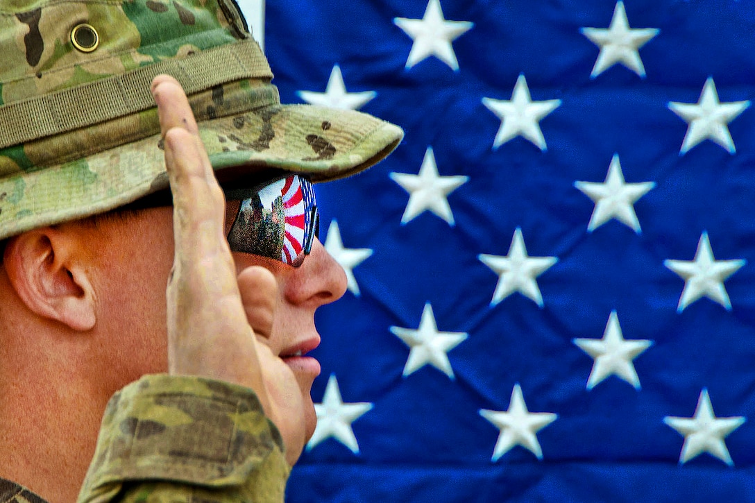 The American flag reflects in the glasses of an U.S. Army officer as he reenlists as a paratrooper on Combat Outpost Qara Baugh in Afghanistan's Ghazni province, April 22, 2012. The soldier is assigned to the 82nd Airborne Division’s 1st Brigade Combat Team.