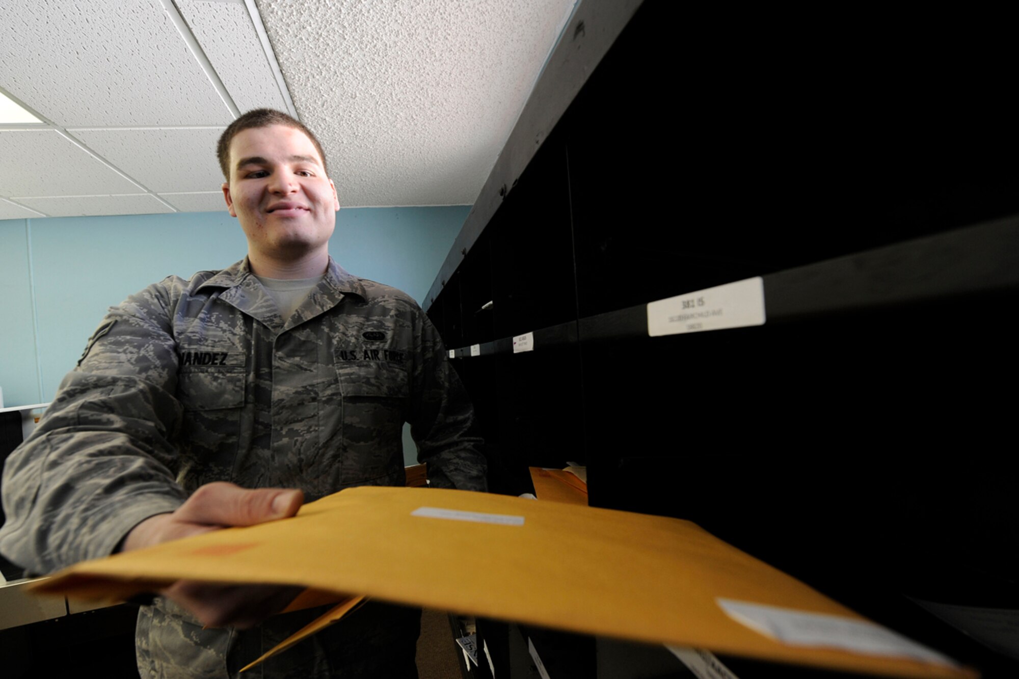 Air Force Airman 1st Class Matthew Fernandez pitches mail April 23 in the Official Mail Center of Joint Base Elmendorf-Richardson, Alaska. The Official Mail Center will be merging with the Official Mail Distribution Center May 14 as part of the joint-basing process. Fernandez is a mail clerk for the 673d Communications Squadron. (U.S. Air Force photo/Staff Sgt. Robert Barnett)