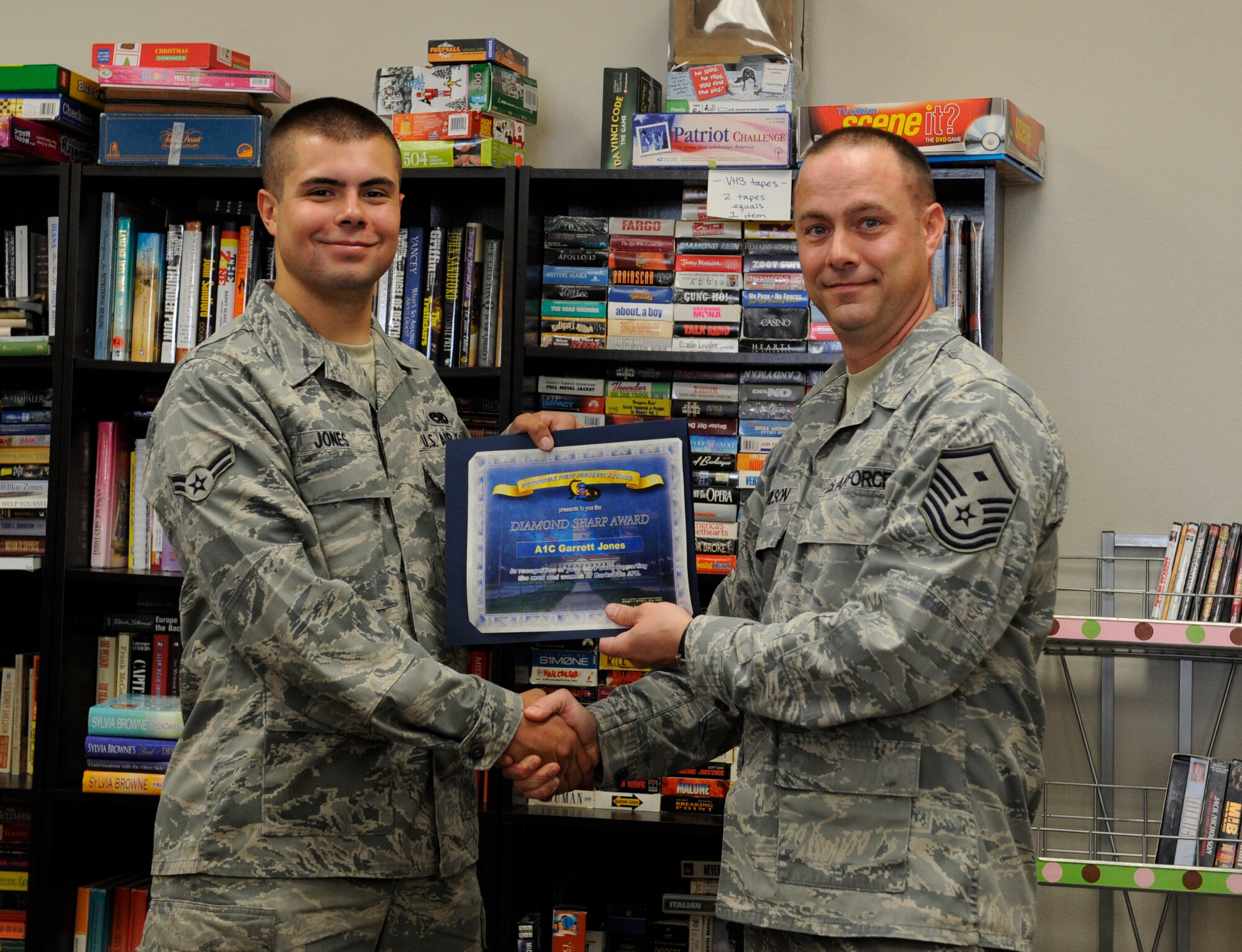 Master Sgt. Bryan Wilson, 2nd Operations Group First Sergeant, presents the Diamond Sharp award to Airman 1st Class Garrett Jones, 2nd Aircraft Maintenance Squadron, at the Airman's Attic on Barksdale Air Force Base, La., April 26. The Diamond Sharp award, presented by the Barksdale First Sergeant Council, recognizes hard-working Airmen who excel at their career, volunteer and show excellence in all they do. Jones was recognized for the volunteer work he has done for the Airman's Attic. (U.S. Air Force photo/Airman 1st Class Benjamin Gonsier)(RELEASED)
