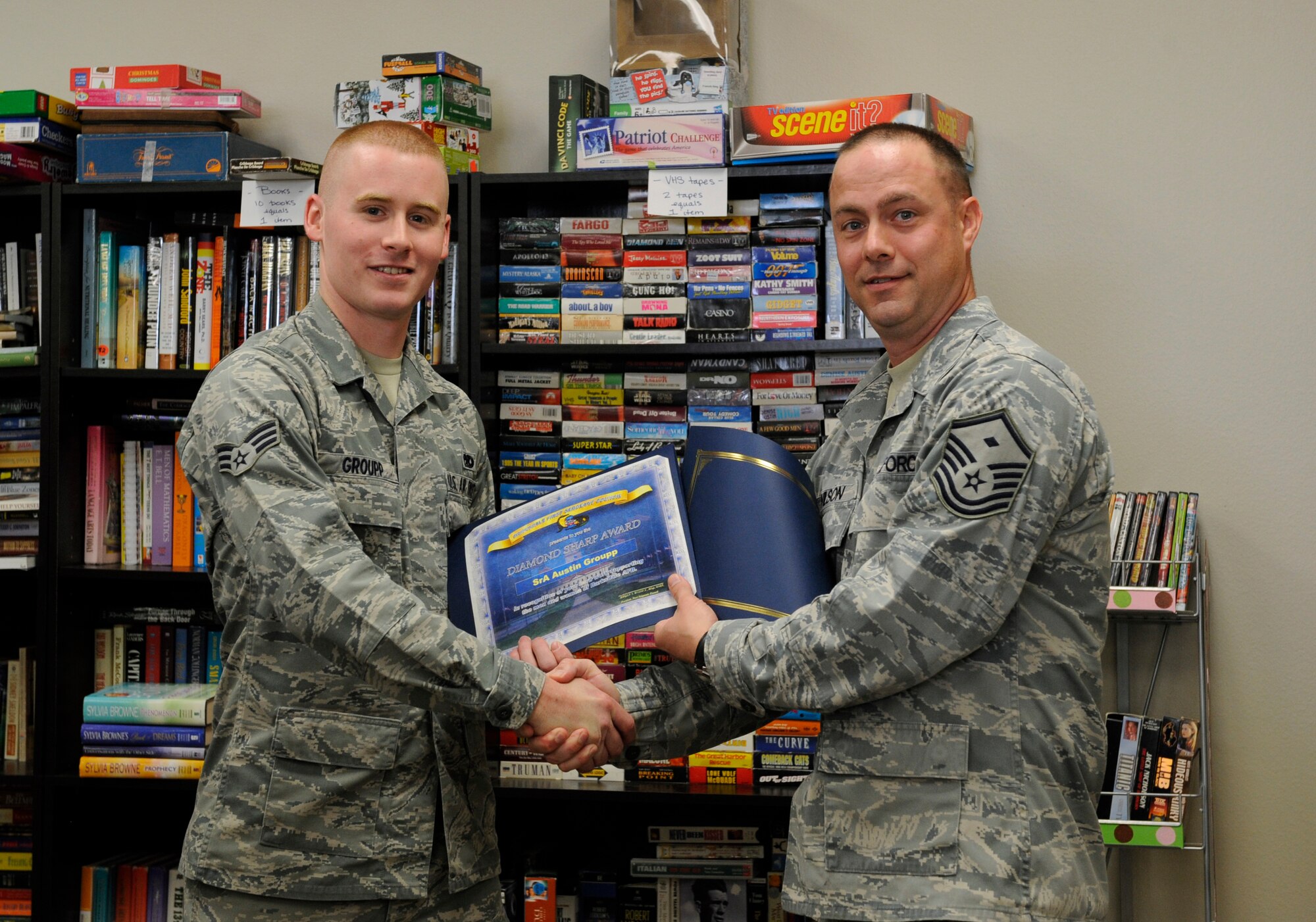 Master Sgt. Bryan Wilson, 2nd Operations Group First Sergeant, presents the Diamond Sharp award to Senior Airman Austin Groupp, 2nd Maintenance Squadron, at the Airman's Attic on Barksdale Air Force Base, La., April 26. The Diamond Sharp award, presented by the Barksdale First Sergeant Council, recognizes hard-working Airmen who excel at their career, volunteer and show excellence in all they do. Groupp was recognized for the volunteer work he has done for the Airman's Attic. (U.S. Air Force photo/Airman 1st Class Benjamin Gonsier)(RELEASED)
