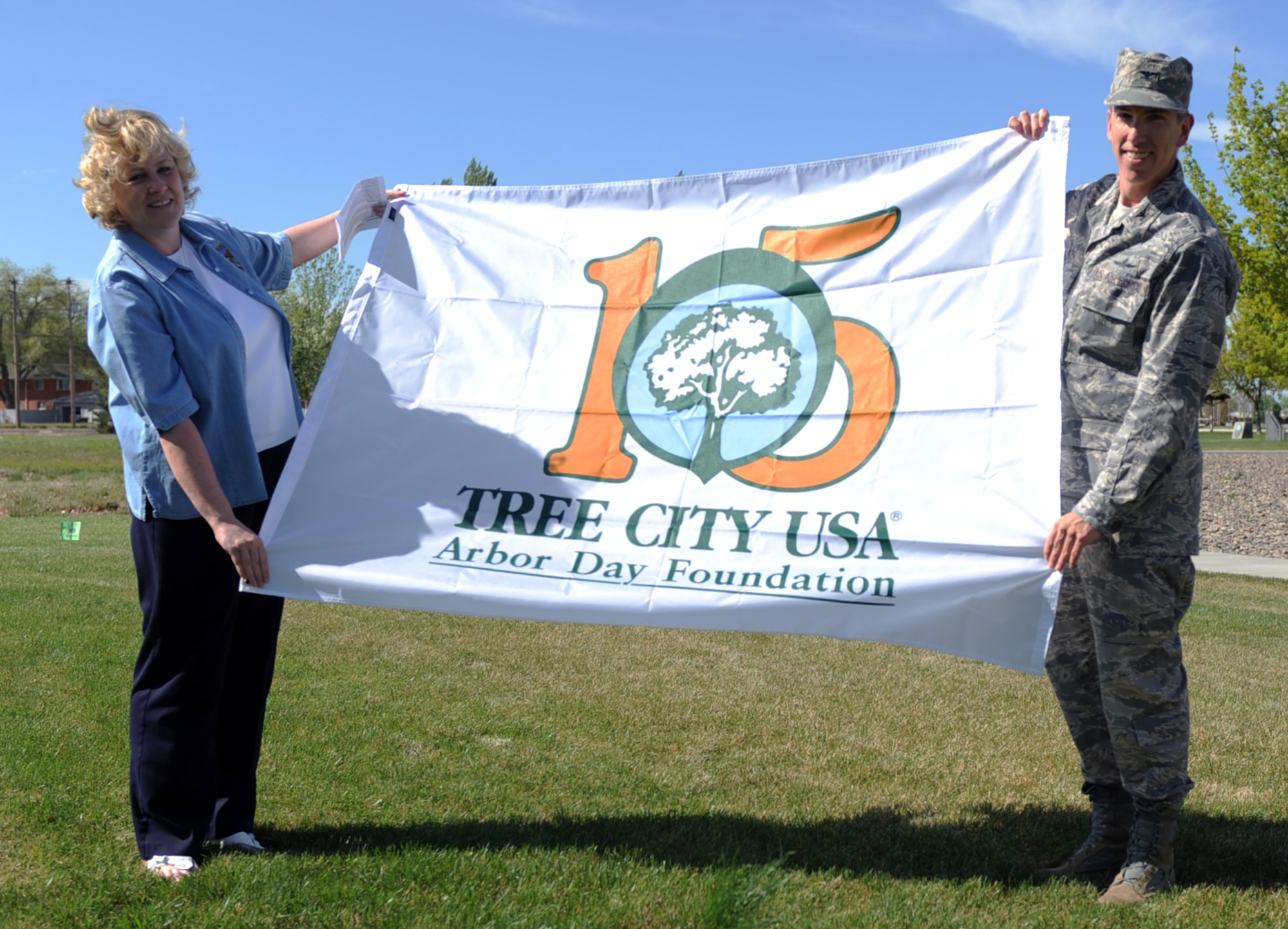 U.S. Air Force Col. Scott Moser, 366th Mission Support Group commander, and Ann Bates, Idaho Tree City Correspondent, hold a flag showing during Arbor Day at Mountain Home Air Force Base, Idaho, April 25, 2012. The base takes part of Arbor Day by planting a tree to help the environment as well as create another new, and reusable resource. (U.S. Air Force photo by/ Airman 1st Class Jonathan Glanville)