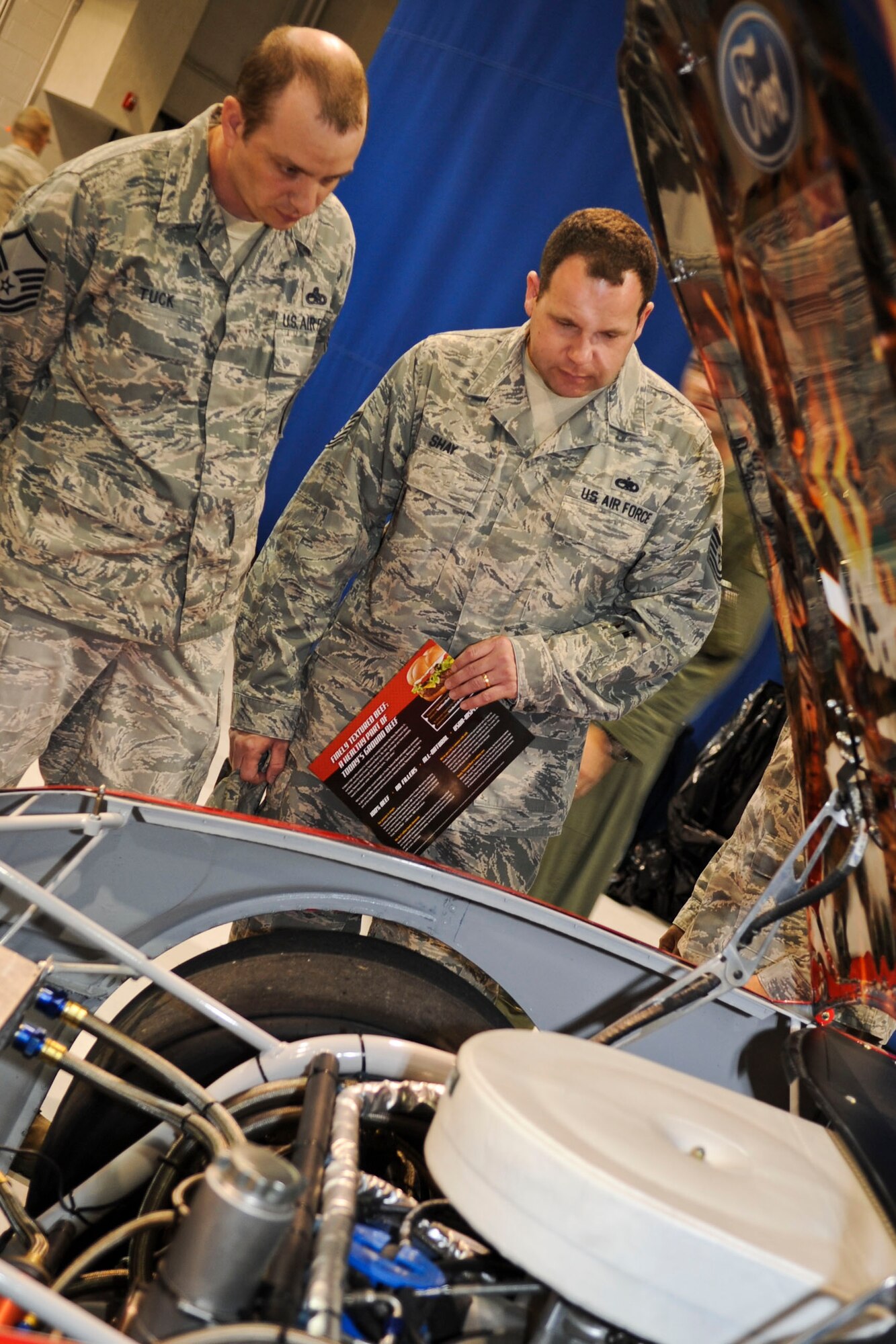 U.S. Air Force Master Sgt. Benjamin Tuck, Air Combat Command weapons safety, and Tech. Sgt. Ron Shay, ACC NCO in charge of flight safety, look under the hood of NASCAR driver Ricky Stenhouse Jr.’s, car, during a military appreciation barbecue on Langley Air Force Base, Va., April 26, 2012. During the lunch, hosted by the 633rd Force Support Squadron, Service members were able to meet Stenhouse and have items autographed. (U.S. Air Force photo by Senior Airman Wesley Farnsworth/Released)