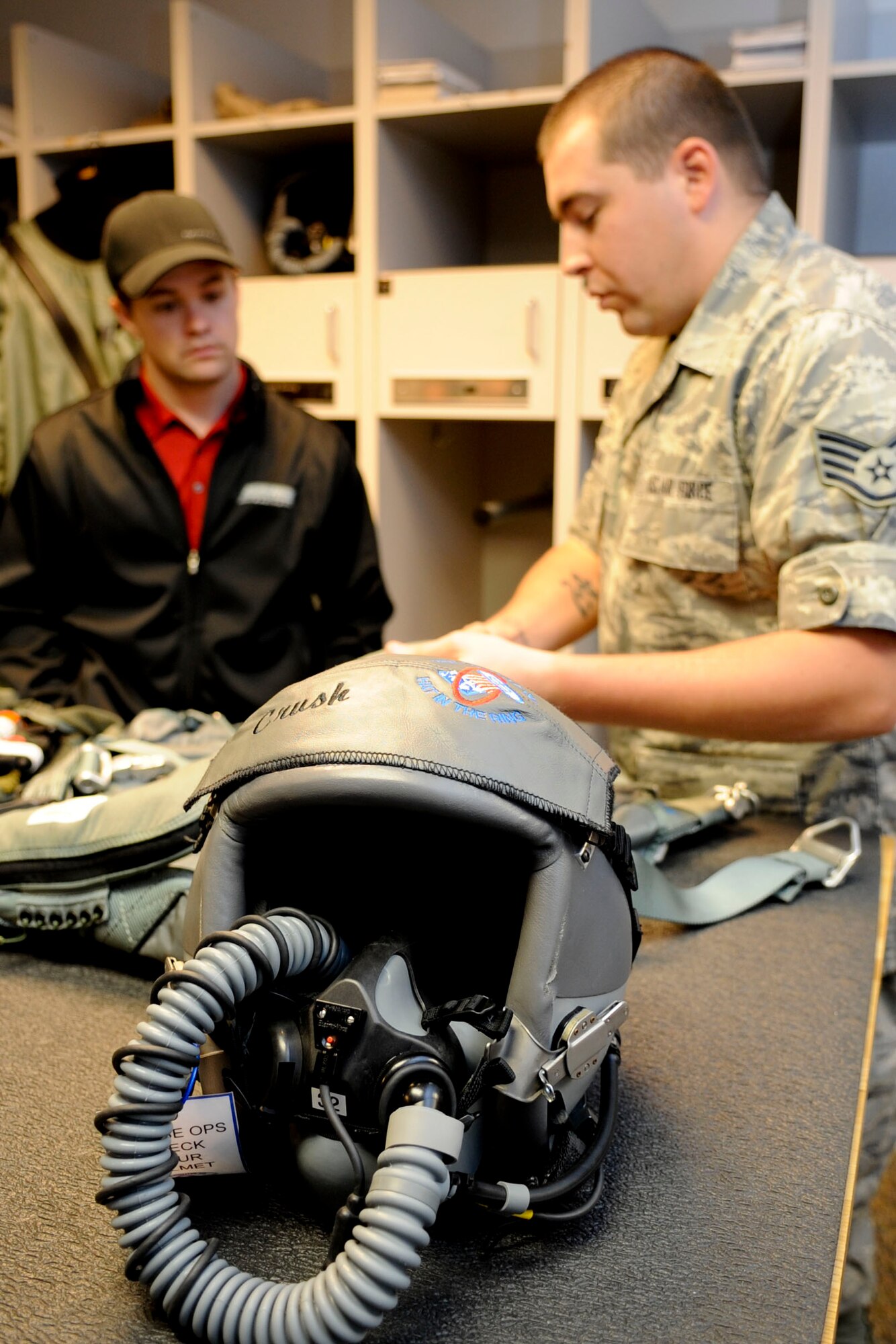 U.S. Air Force Staff Sgt. George Sherman, 1st Operations Group flight equipment section chief, explains functions of the safety equipment pilots wear while performing their duties to NASCAR driver Ricky Stenhouse, Jr., during a tour of of Langley Air Force Base, Va., April 26, 2012. Sternhouse learned about helmets, flight suits and night-vision goggles. (U.S. Air Force photo by Senior Airman Wesley Farnsworth/Released)