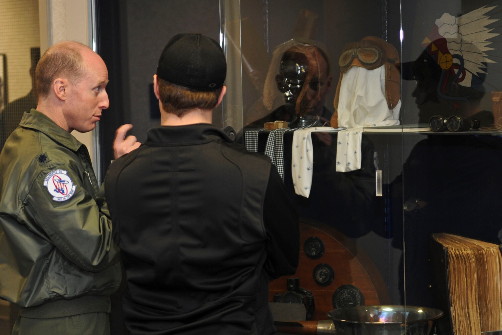 U.S. Air Force Lt. Col. Jason Hinds, 94th Fighter Squadron commander, explains the display of historical pilot gear to NASCAR driver Ricky Stenhouse, Jr., during a tour of Langley Air Force Base, Va., April 26, 2012. During the tour, Stenhouse visited several offices to visit troops, and participated in a military appreciation barbecue. (U.S. Air Force photo by Senior Airman Wesley Farnsworth/Released)