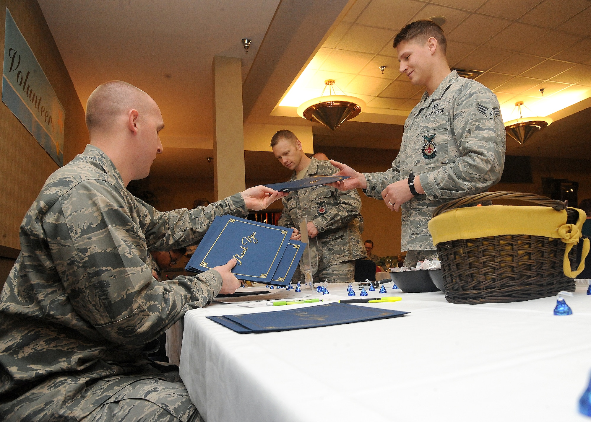 (From left) 1st Lt. Bryan Ingram, 319th Logistics Readiness Squadron, hands Senior Airman Shane Holland, 319th Civil Engineer Squadron, a certificate of recognition during the annual Volunteer Appreciation Luncheon on April 20, 2012, on Grand Forks Air Force Base, N.D.  (U.S. Air Force photo by Airman 1st Class Xavier Navarro)