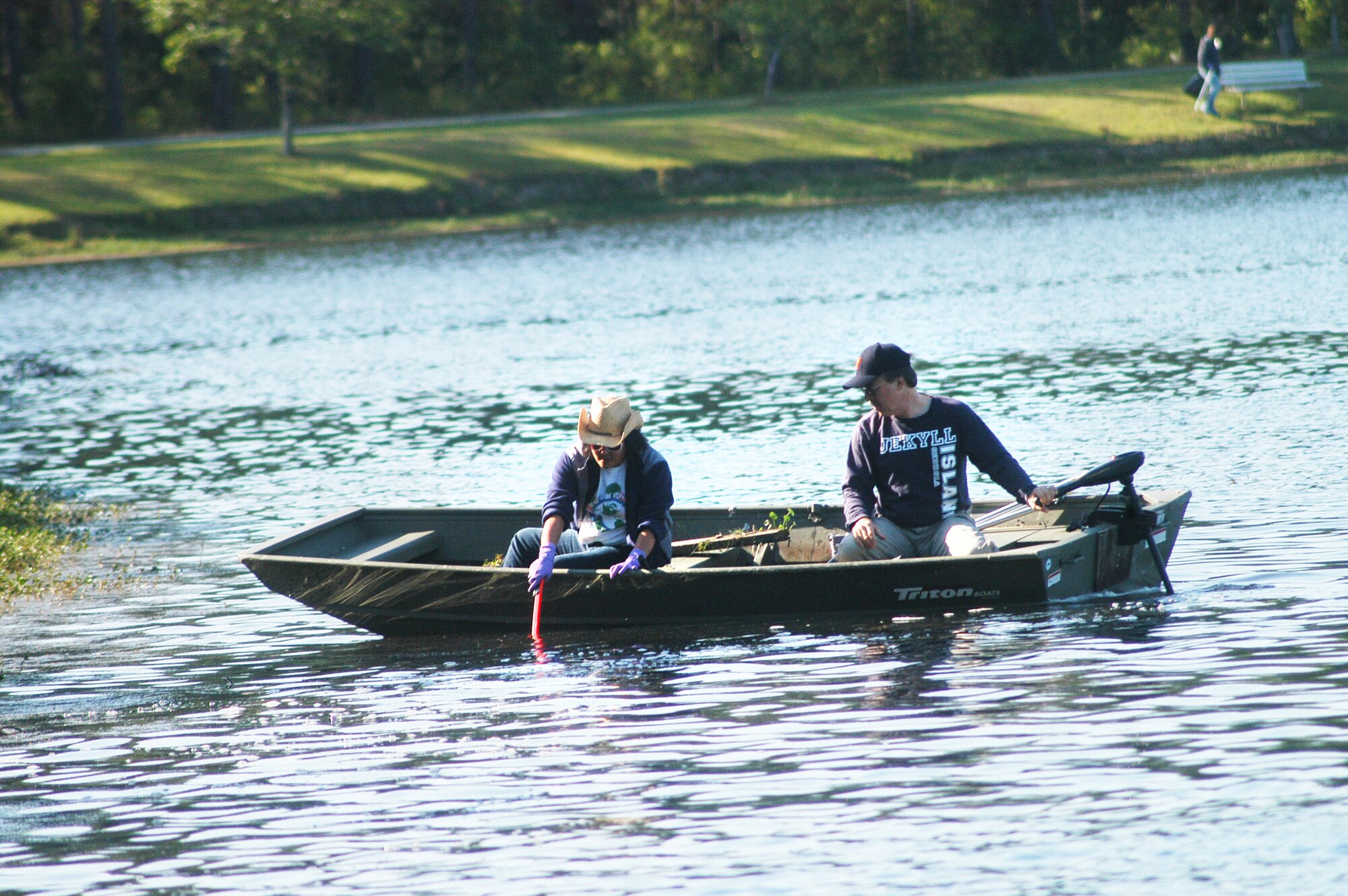 Esther Lee-Altman and Bob Sargent, 78th Civil Engineer Group, use a boat to collect debris from Scout Lake Wednesday. The clean-up was part of the Robins Air Force Base Earth Day Celebration events. (U. S. Air Force photo by Sue Sapp)