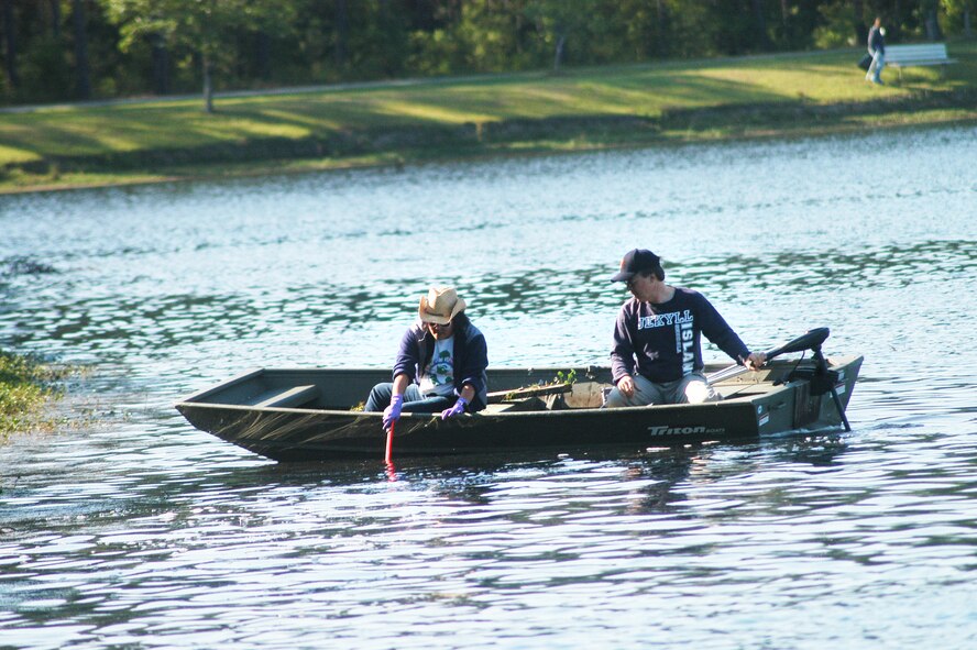 Esther Lee-Altman and Bob Sargent, 78th Civil Engineer Group, use a boat to collect debris from Scout Lake Wednesday. The clean-up was part of the Robins Air Force Base Earth Day Celebration events. (U. S. Air Force photo by Sue Sapp)
