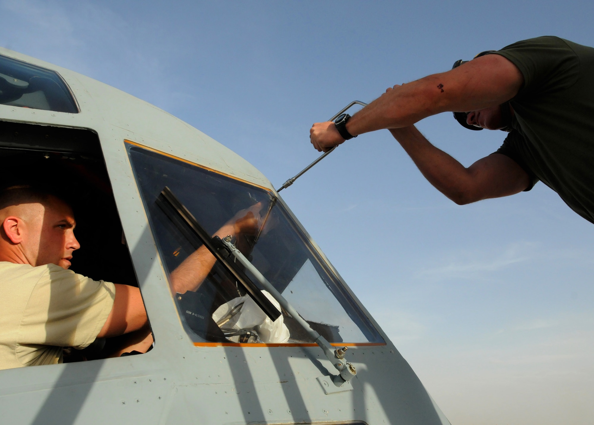 Tech. Sgt. Todd Gagnon (left), 451st Expeditionary Aircraft Maintenance Squadron C-130J crew chief, deployed from Little Rock Air Force Base, Ark., helps Corporal Ryan Kraus (right), Marine Aerial Refueler Transport Squadron 352 KC-130J airframes mechanic, extract an old windshield to replace it here at Kandahar Airfield, Afghanistan, April 15, 2012. The two participated in a joint training exchange aimed at teaching different maintenance techniques as well as instilling inter-service communication and cooperation. (U.S. Air Force photo/Staff Sgt. Heather Skinkle)