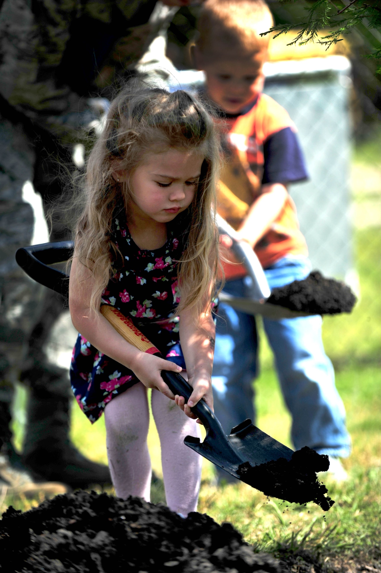 Jaymesan Weekley shovels dirt during a tree planting ceremony at the Langley Air Force Base, Va., child development center, April 25, 2012. Jaymesan was taught that if trees like the one she helped plant were properly cared for, they could live to be hundreds of years old. (U.S. Air Force photo by Senior Airman Jarad A. Denton/Released)