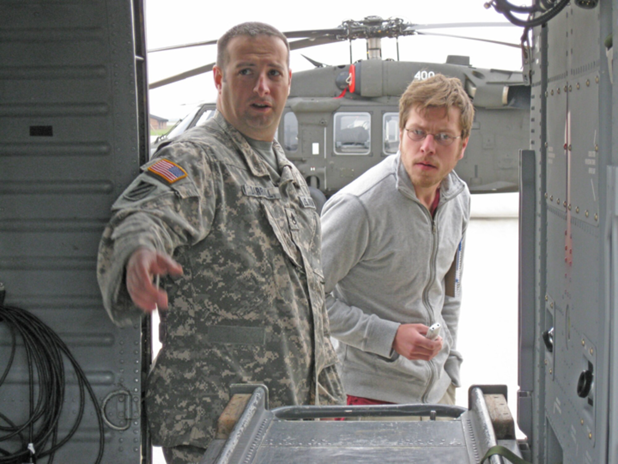 GRISSOM AIR RESERVE BASE, Ind., -- Sergeant Scott Darrall, a flight medic and platoon sergeant with the Indiana Army National Guard, shows reporter Carson Gerber the interior of a UH-60 Black Hawk helicopter.  Elements of the 2-238th Medevac unit are at Grissom for pre-mobilization training and took time out of their schedule to provide members of the press with an overview of their mission. Mr. Gerber is a reporter with the Kokomo Tribune newspaper.   (U.S. Air Force photo/Lt Col Gary Lockard)                         