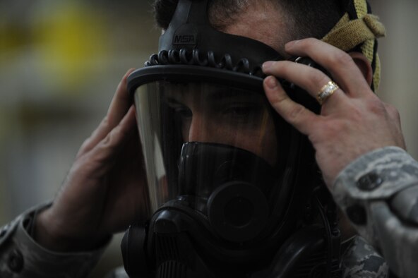 Tech. Sgt. Michael Gonzalez, 39th Civil Engineer Squadron emergency management NCO in charge of training, dons his gas mask April 25, 2012, at Incirlik Air Base, Turkey. Emergency management is responsible for ensuring base preparedness in the event of a natural disaster, terrorist attack and hazardous material mishap. (U.S. Air Force photo by Senior Airman Jarvie Z. Wallace/Released)