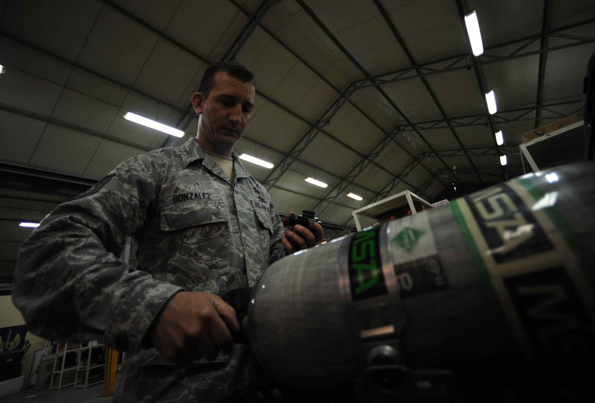 Tech. Sgt. Michael Gonzalez, 39th Civil Engineer Squadron emergency management NCO in charge of training, checks the air levels on a self-contained breathing apparatus air tank April 25, 2012, at Incirlik Air Base, Turkey. Emergency management is responsible for ensuring base preparedness in the event of a natural disaster, terrorist attack and hazardous material mishap. (U.S. Air Force photo by Senior Airman Jarvie Z. Wallace/Released)
