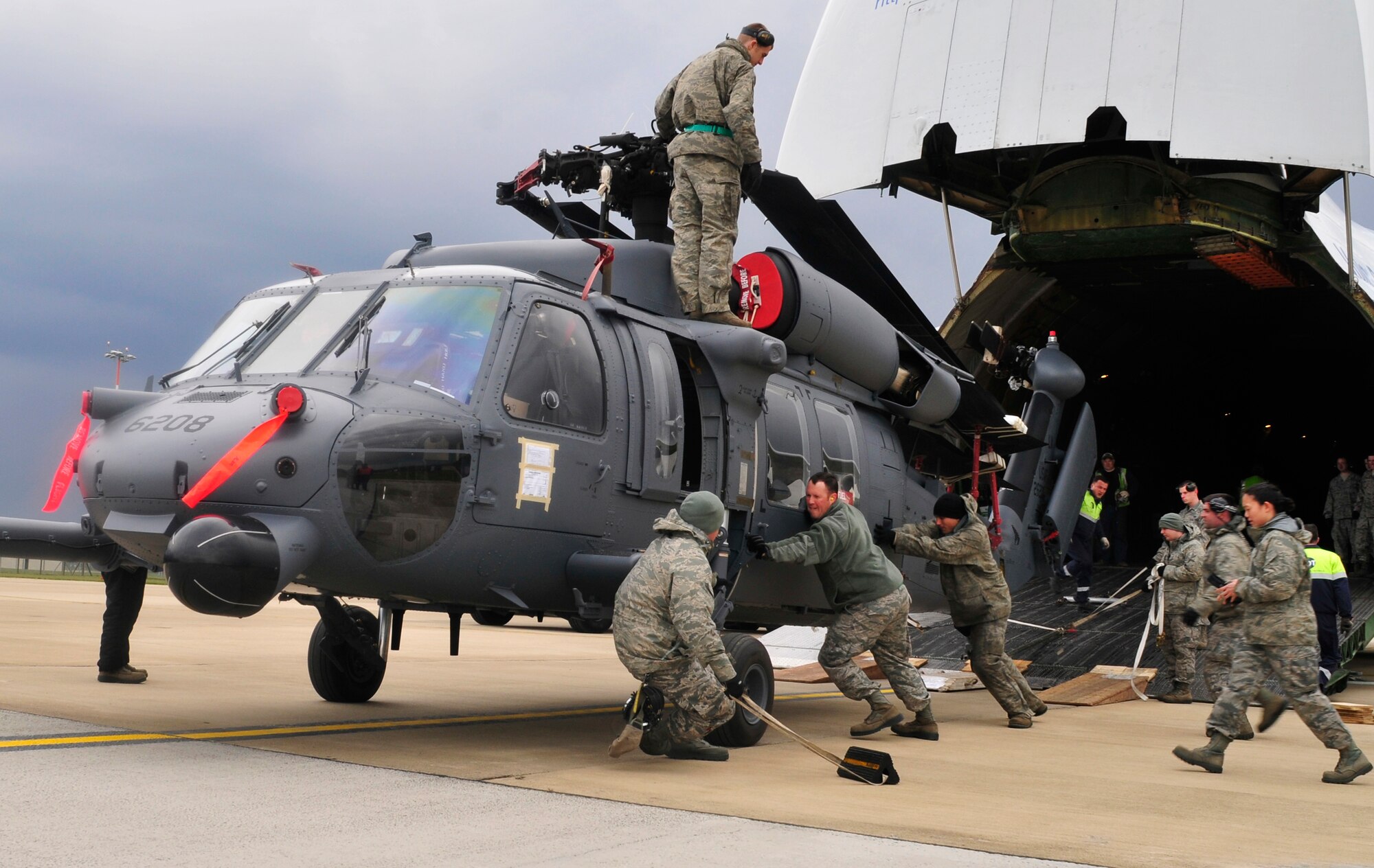 ROYAL AIR FORCE LAKENHEATH, England - Airmen of the 48th Fighter Wing work together to unload an HH-60 Pave Hawk from an AN-124 Antonov, a civilian Russian transport carrier, on the flightline April 20, 2012. The helicopter was being returned to RAF Lakenheath after undergoing Joint Depot Level Maintenance at Korean Airlines Limited for eight months. All aircraft undergo this process every 72 months to extend the life of the 56th Rescue Squadron's fleet. (U.S. Air Force photo by Senior Airman Tiffany M. Deuel) 