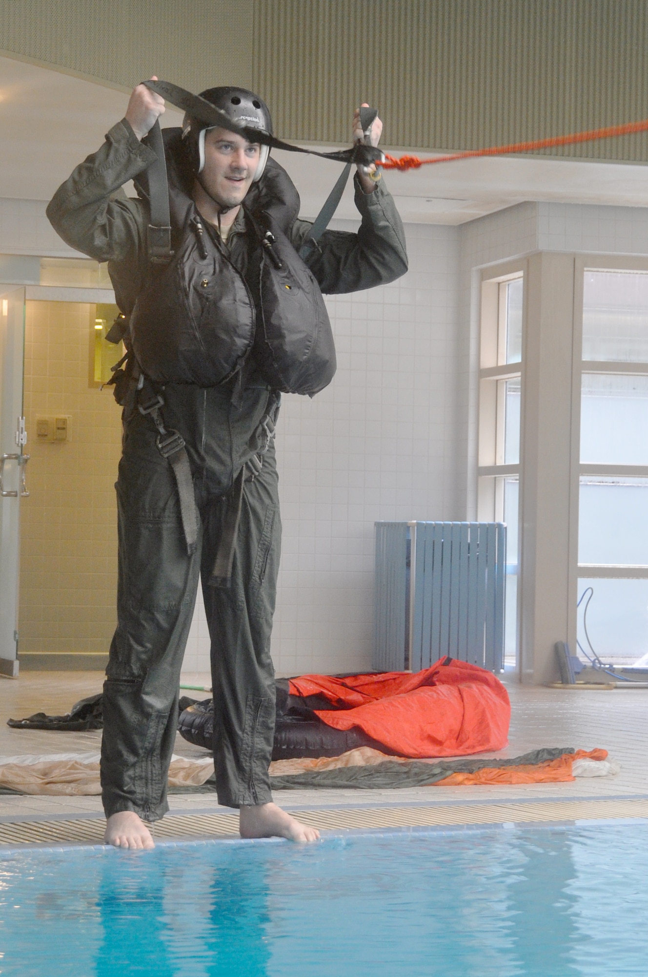 Capt. Brent Choate, 36th Fighter Squadron pilot, prepares to jump into the base pool during water survival training here, April, 23, 2012. Choate’s training consisted of being dragged through the water to mimic the feeling of wind catching the canopy of the parachute. (U.S. Air Force photo/Staff Sgt. Stefanie Torres)