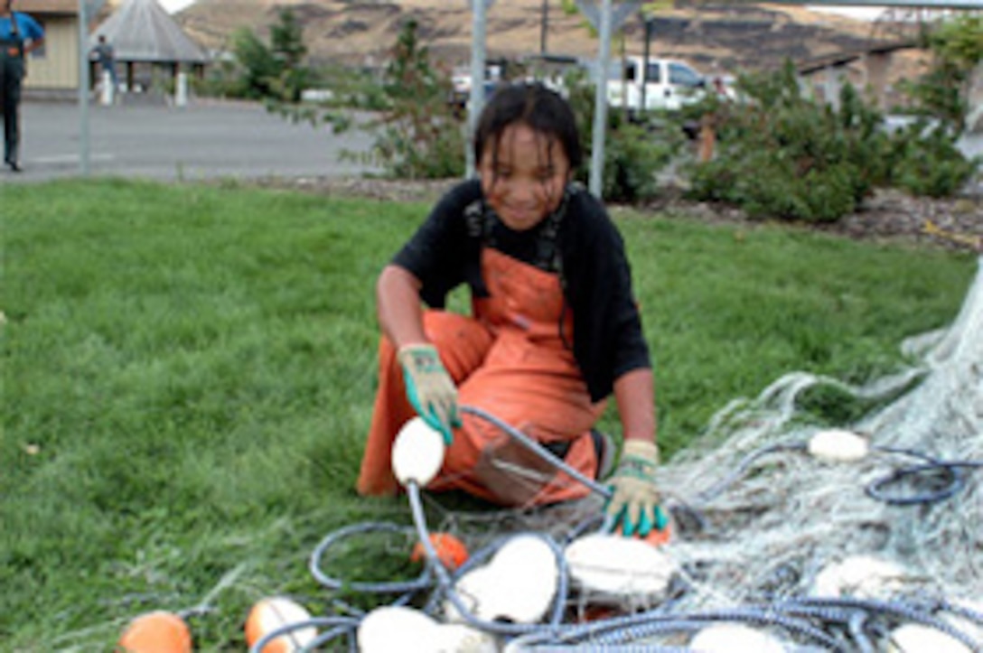 Tribal member demonstrates fishing equipment maintenance.