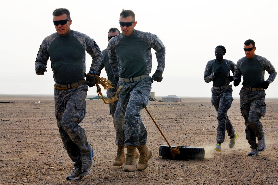 U.S. Army Lt. Col. Stephen Dawson, left, leads his team through a tire drag during the Tough Mudder Centurion Challenge on Camp Buehring, Kuwait, April 21, 2012. Dawson commands the 1st Cavalry Division's 1st Brigade Special Troops Battalion, 1st Brigade Combat Team.