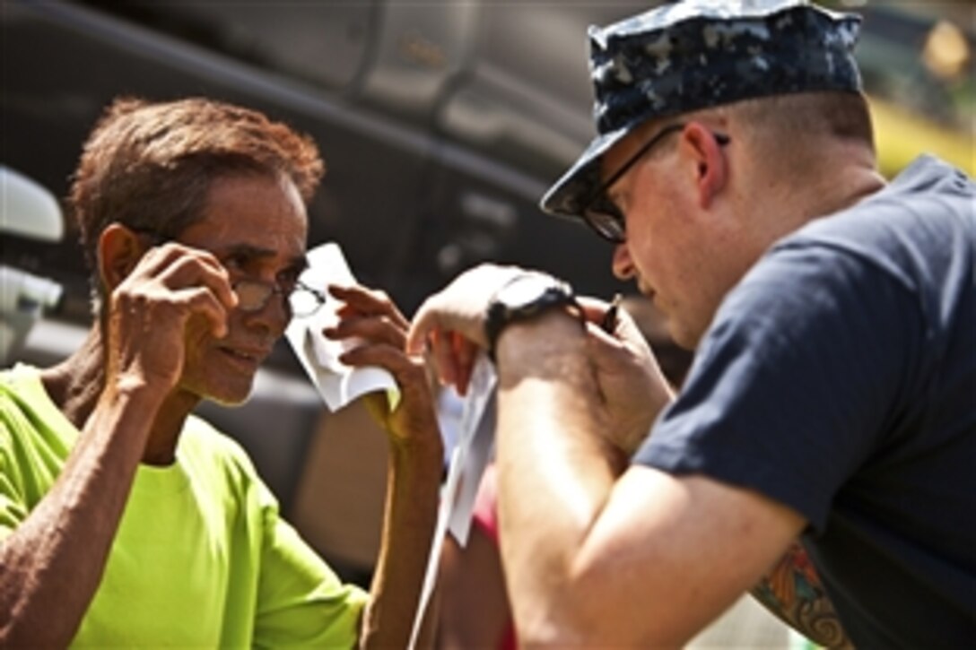 U.S. Navy Petty Officer 1st Class Chris Lebel checks a patient's eyes during a medical civic assistance project at Kandis Elementary School as part of Exercise Balikatan 2012 in Puerto Princesa, Philippines, April 18, 2012. Balikatan is an annual bilateral training exercise aimed at improving interoperability between U.S. and Philippine military forces.