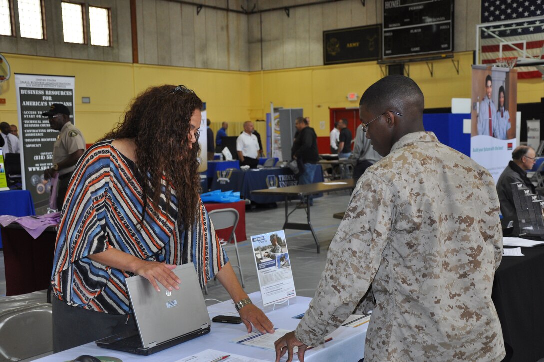 Lisa Rich, director of military relations with Education Management Corporation online higher education, speaks to Pfc. Stephone Duncan, supply clerk with base supply, about furthering his education online during the Career and Education Expo aboard Marine Corps Logistics Base Barstow April 26. ::r::::n::
