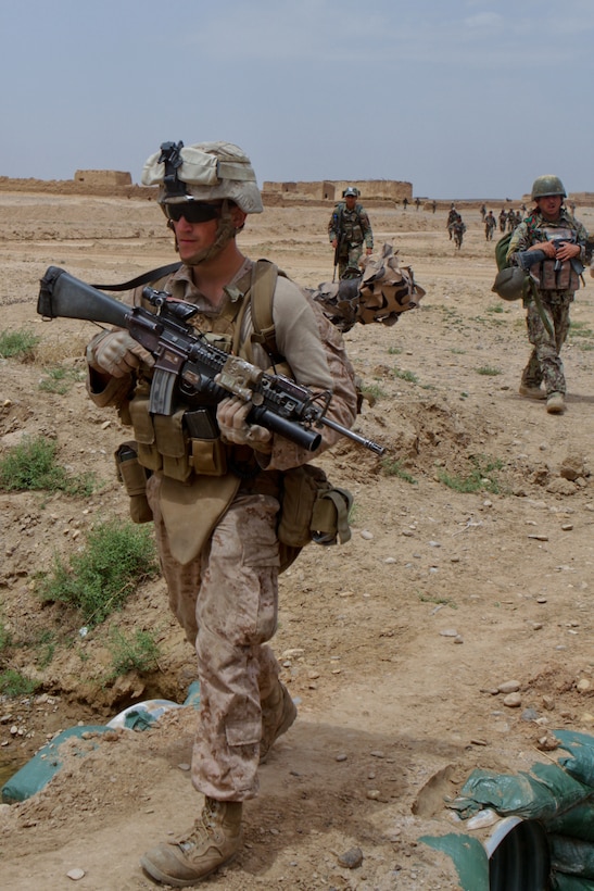 Lance Cpl. Brandon Debruler, a squad automatic weapon gunner with Weapons Company, 2nd Battalion, 6th Marine Regiment, patrols through an open field with his Afghan National Army counterparts, April 26, 2012. Marines with 2nd Bn., 6th Marines participated in a support role during, the Afghan-led, Operation High Noon 15.::r::::n::::r::::n::::r::::n::