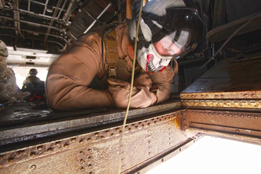 Staff Sgt. Philip Michel, a Crew Chief with Marine Heavy Helicopter Squadron 466, observes fuel bladders being carried underneath a CH-53E Super Stallion en route to northern Helmand province, Afghanistan, April 26. Two CH-53E Super Stallions from HMH-466 transported approximately 2,000 pounds of fuel to 1st Tank Battalion.