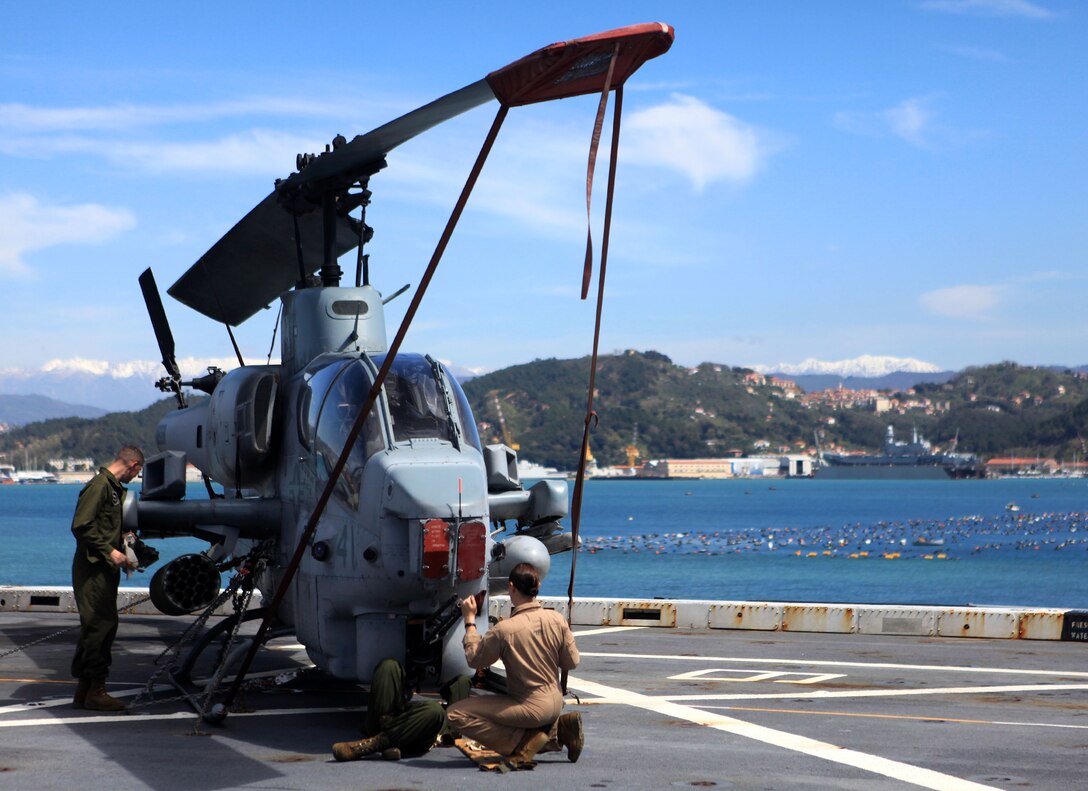 Marines with Marine Medium Tiltrotor Squadron 261 (Reinforced), 24th Marine Expeditionary Unit, perform routine corrosion treatment on a AH-1W Cobra here as the ship departs La Spezia, Italy, April 26, 2012, after a port visit. The 24th MEU is currently deployed with the Navy's Iwo Jima Amphibious Ready Group as a theater reserve and crisis response force capable of a variety of missions from full-scale combat operations to humanitarian assistance and disaster relief.